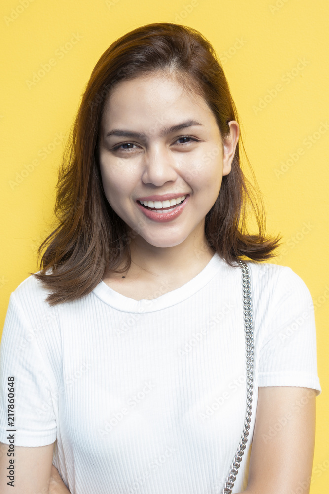 portrait of beautiful university student are smiling on yellow wall background portrait of beautiful university student are smiling on yellow wall background