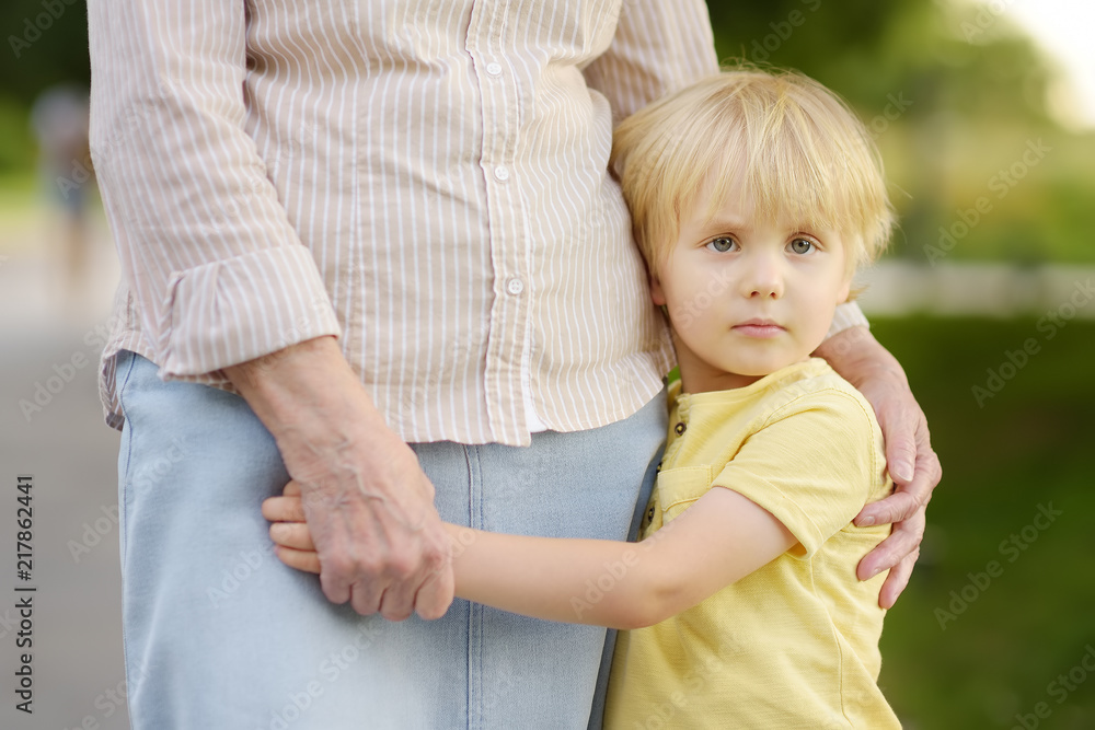 Beautiful granny and her little grandson walking together in park Beautiful granny and her little grandson walking together in park