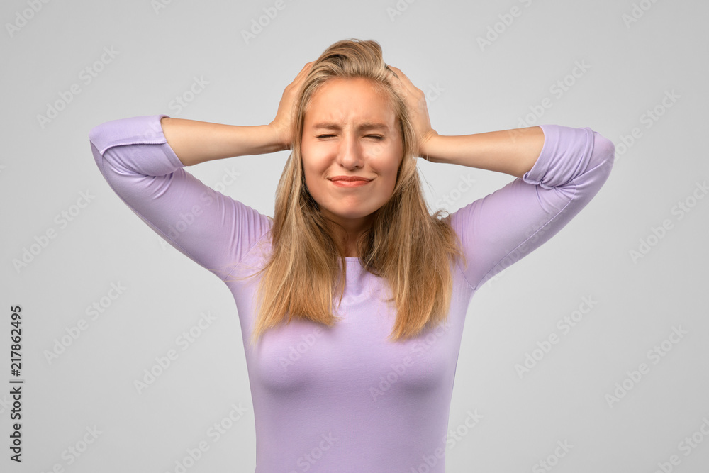Worried woman closing her eyes holding hands on head having headache after sleepless night. Young female in depression looking sick and tired of work. Troubled woman having serious problems in life Worried woman closing her eyes holding hands on head having headache after sleepless night. Young female in depression looking sick and tired of work. Troubled woman having serious problems in life
