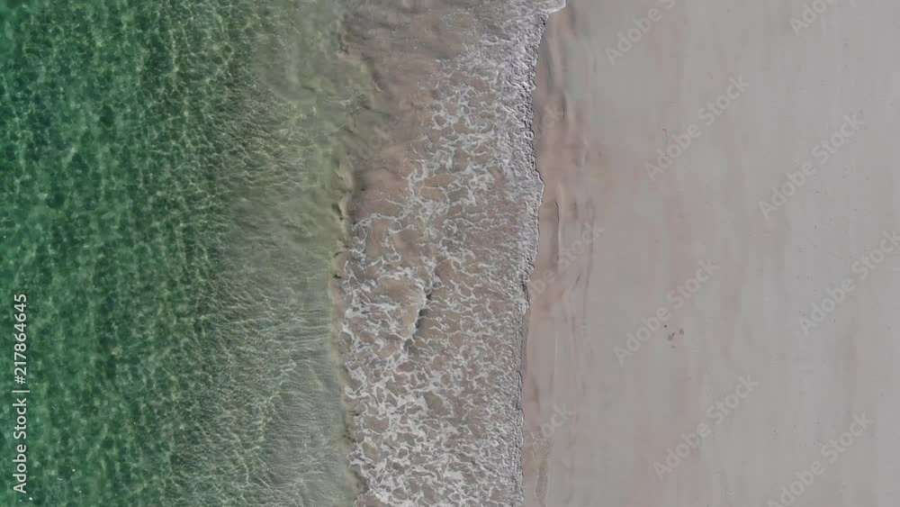 Idyllic green ocean lapping waves onto beach, Aerial Top View Pull Back Idyllic green ocean lapping waves onto beach, Aerial Top View Pull Back