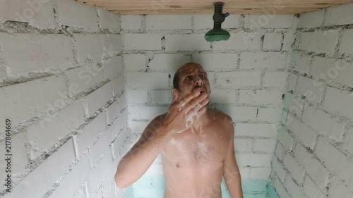 Worried caucasian foamed young man after the water in the shower was turned off. Shower breakdown or hot water shut-off.