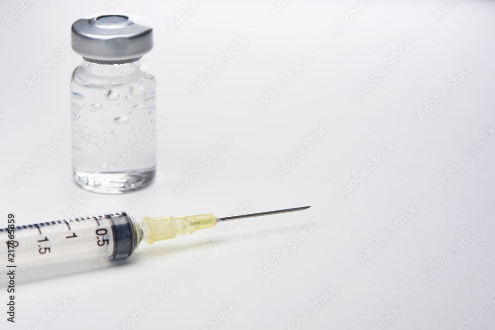 A syringe and bottle of medication on white background A syringe and bottle of medication on white background