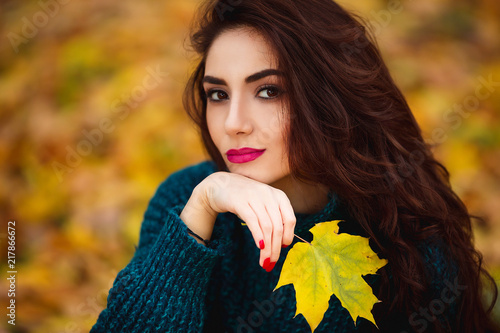 Beautiful young woman. Dramatic outdoor autumn portrait of sensual brunette female with long hair. Sad and serious girl.