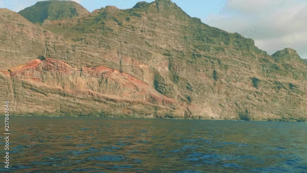 View of cliffy shore of Gran Canaria from board of floating yacht saling in ocean View of cliffy shore of Gran Canaria from board of floating yacht saling in ocean