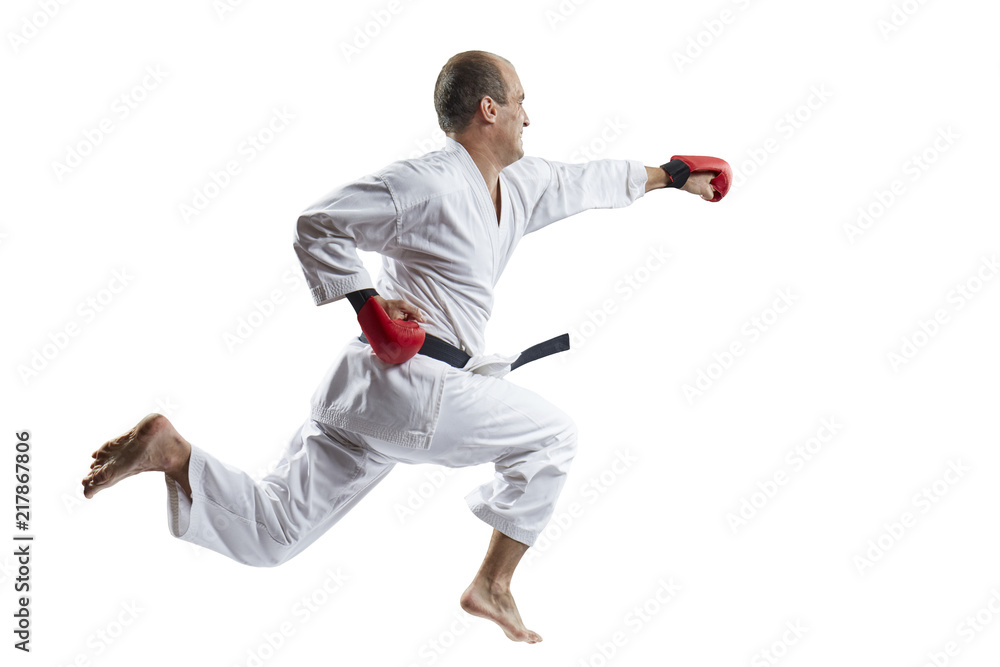 Man strikes with a hand in a jump against a white background