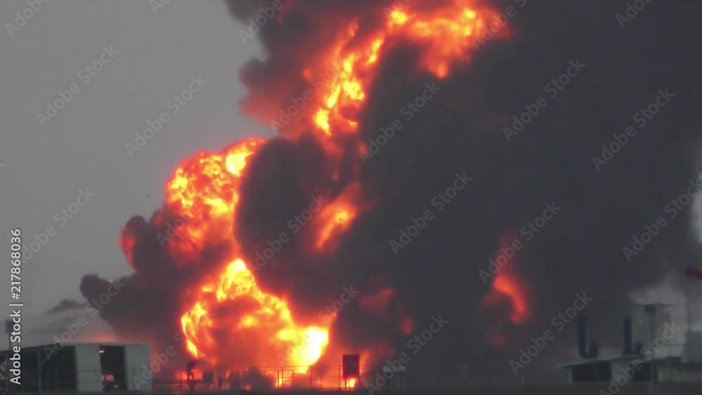 Huge fire blaze from burning oil container in refinery. Firefighter ...