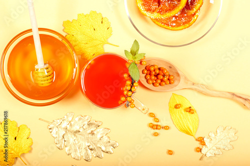 чай из облепихи мёд апельсины ягоды лежат на столе 