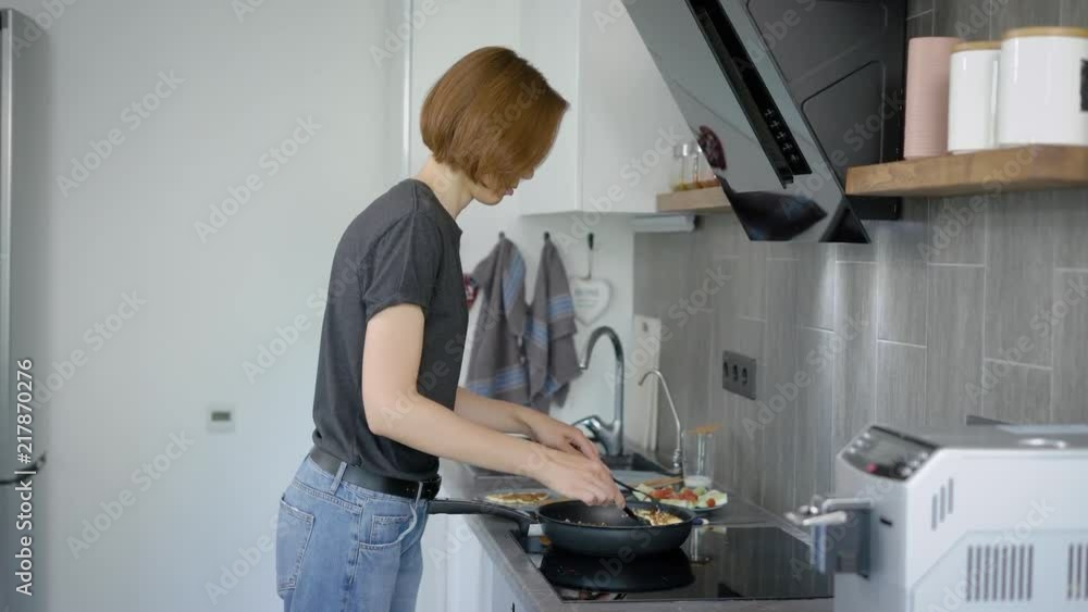 Wonderful woman with short red hair cooking delicious breakfast at home. Wonderful woman with short red hair cooking delicious breakfast at home.