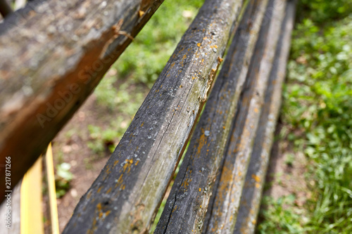 Surface of old wooden sticks arranged herringbone. Wooden fence close up background. Old wooden fence on the sand.