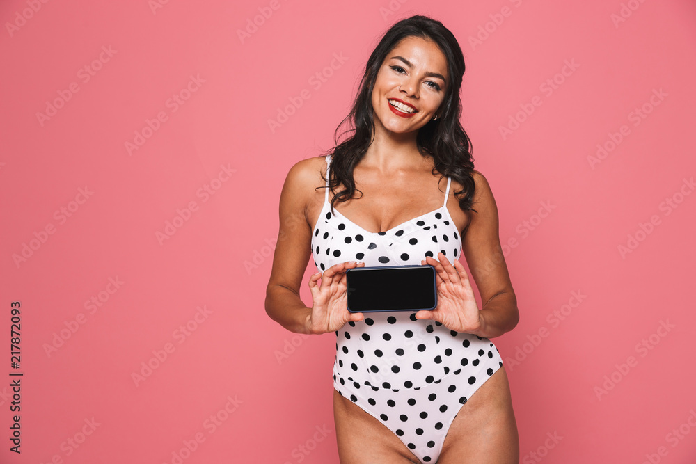Cheerful woman in swimwear showing display of mobile phone. Cheerful woman in swimwear showing display of mobile phone.