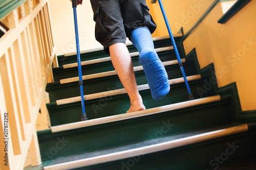 men with broken foot and crutches on stairs