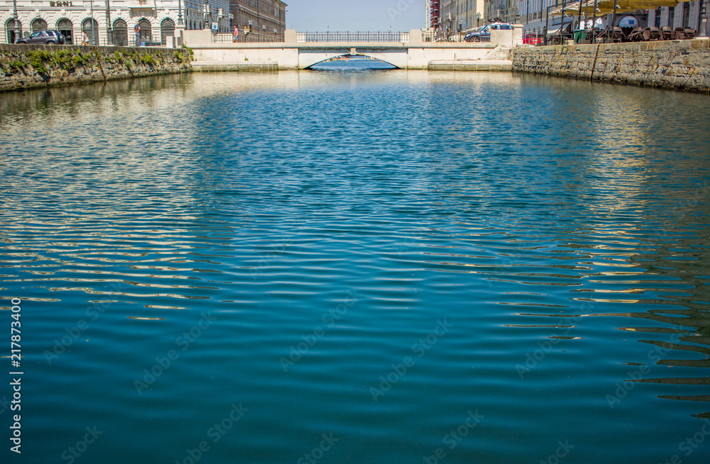 water surface background and small waves canal in small city district near sea with bridge and alley way for walk