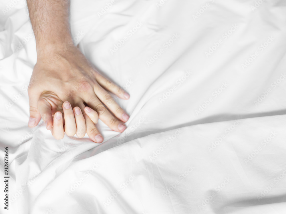 man and woman hands having sex on a bed. make love man and woman hands having sex on a bed. make love