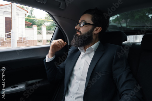 Confident businessman sitting on the car back sit © arthurhidden