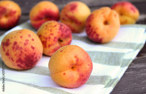 Ripe organic apricots on the wooden background. Space for text. Blurred background.