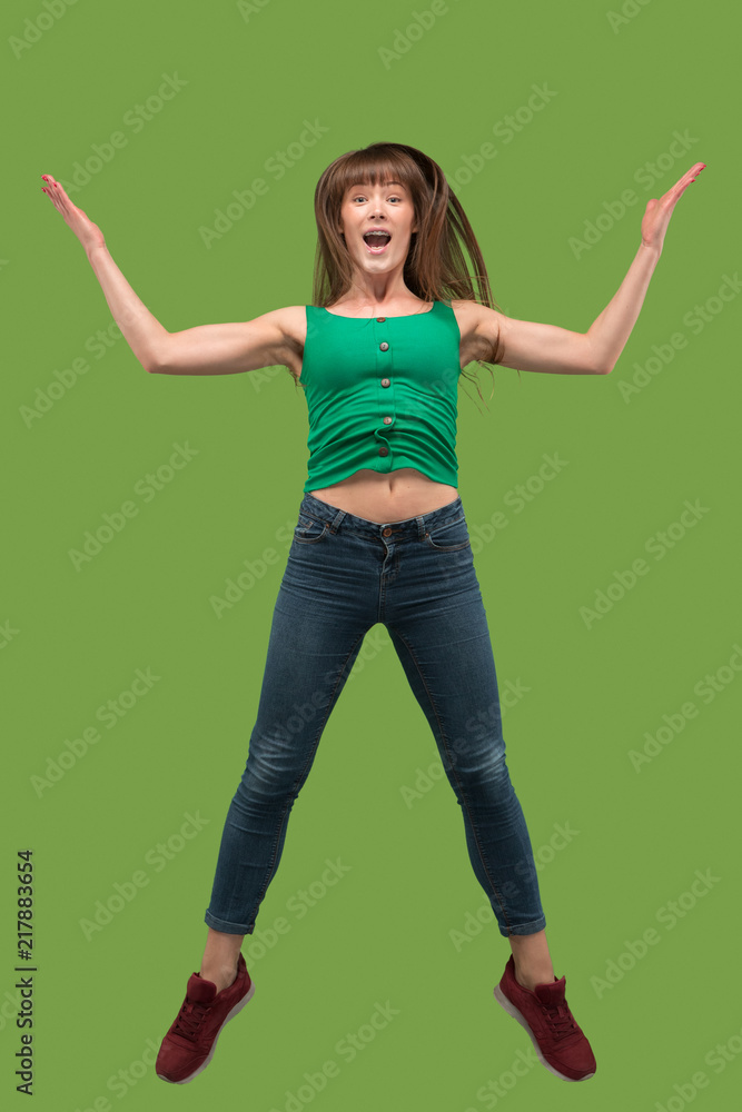Freedom in moving. Pretty young woman jumping against orange background Freedom in moving. Pretty young woman jumping against orange background