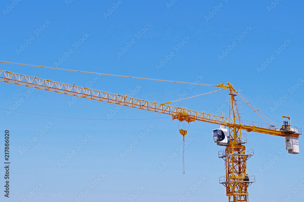 yellow construction crane tower on background of blue sky yellow construction crane tower on background of blue sky