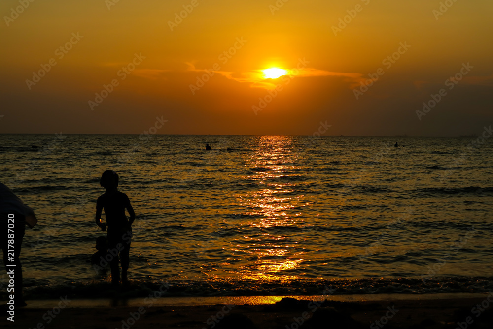 silhouette woman run away from kid to beach and sunset