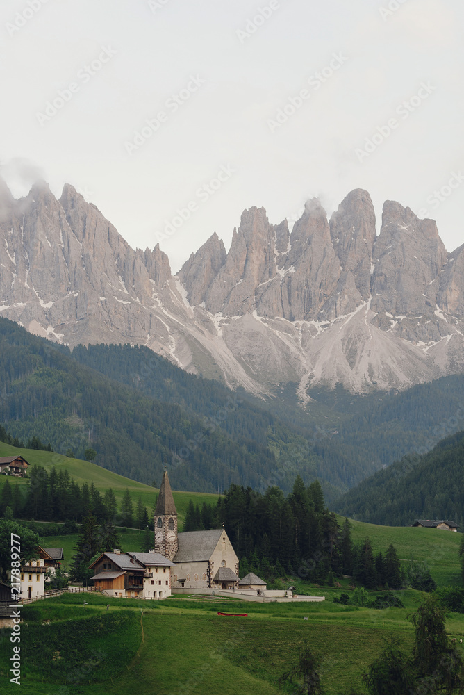 Look from afar at a church somewhere in Italian Dolomites