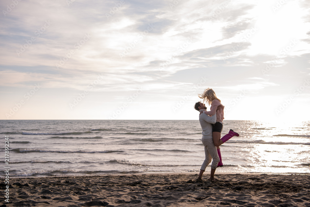 Loving young couple on a beach at autumn sunny day
