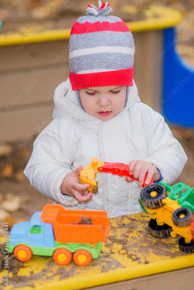 the child plays cars on the playground the child plays cars on the playground