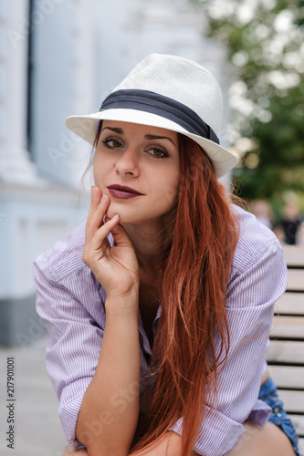 Portrait of beautiful redhair woman in a hat, summer outdoors