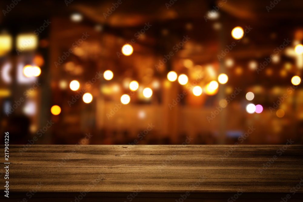 Image of wooden table in front of abstract blurred restaurant lights background Image of wooden table in front of abstract blurred restaurant lights background