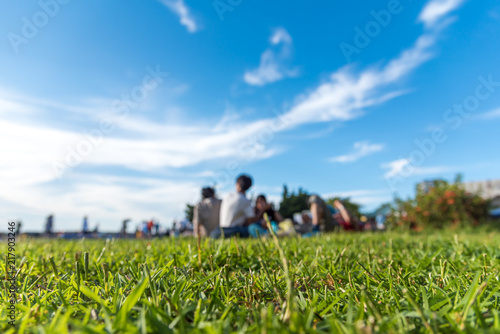 Friends and family having fun on a picnic on the lawn with bright blue sky. selectes focus.