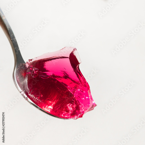 Red sweet jelly on a spoon