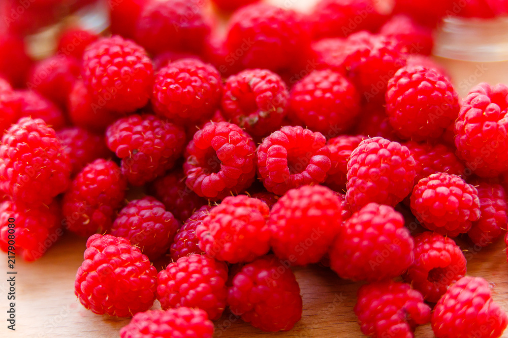 Juicy raspberries lying on wooden cutting board macro Juicy raspberries lying on wooden cutting board macro