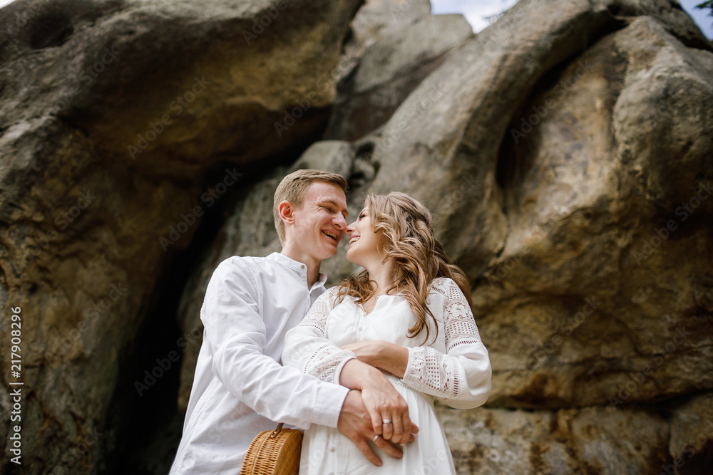 Happy pregnant family having fun time in summer nature. 