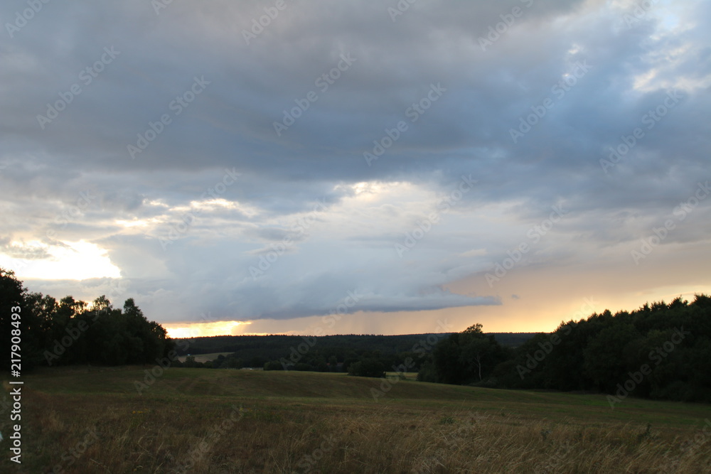 Fototapeta premium Sonnenaufgang versteckt hinter Gewitterwolken