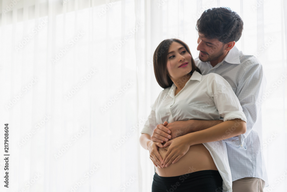 Beautiful asian pregnant woman and her handsome husband hugging the tummy. woman and man making shape heart. concept of family lover Beautiful asian pregnant woman and her handsome husband hugging the tummy. woman and man making shape heart. concept of family lover