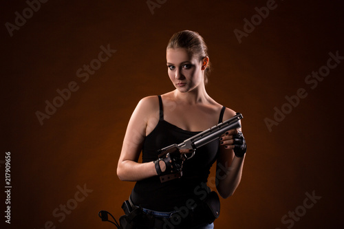 Pistol shooting on dark red background. Sportsman with a gun. Sport pistol shooting. photo