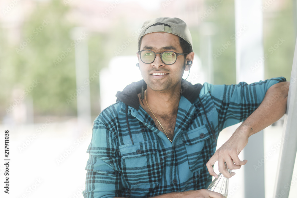 Junger Mann mit Kappe, Trinkflasche und Brille Junger Mann mit Kappe, Trinkflasche und Brille