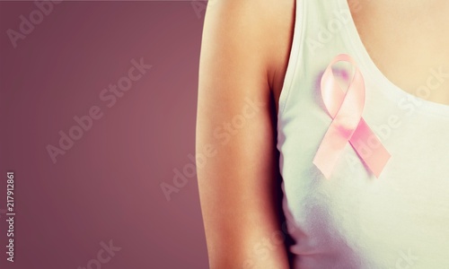 Woman chest with pink badge to support breast cancer cause,