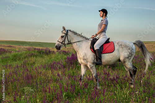 Horsewoman jockey in uniform riding horse outdoors © nazarovsergey