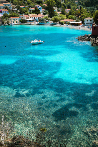 Assos village, Kefalonia Greece. Transparent turquoise emerald green sea water with dark pattern on bottom in lagoon