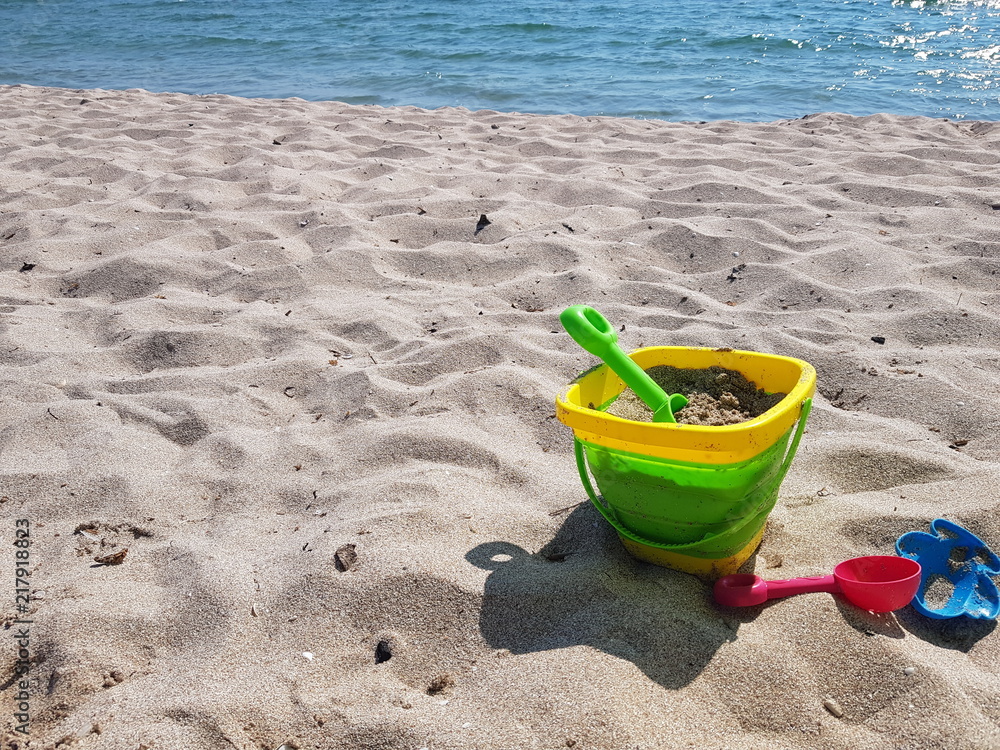 children's toys on the beach with white sand on a sunny day children's toys on the beach with white sand on a sunny day