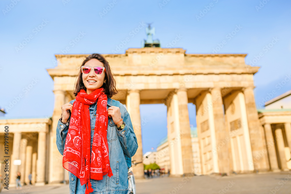 Fototapeta premium Podróżna turystyczna kobieta przy Brandenburg bramą lub Brandenburger Tor przy zmierzchem