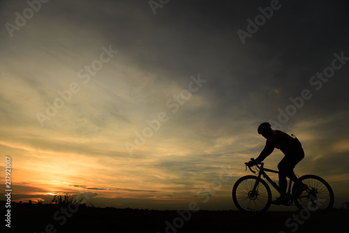 Silhouette of biker ride bicycle on sunset