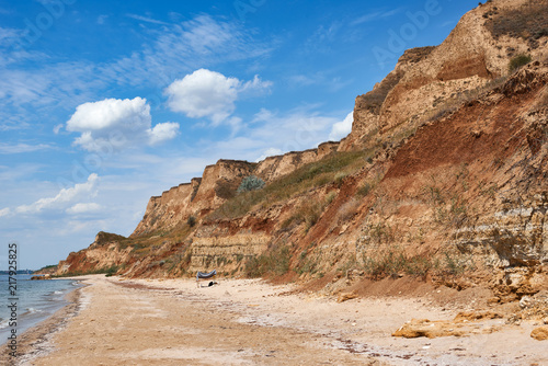 beautiful sea summer landscape, wild beach closeup, sea coast with high hills and cloudy sky