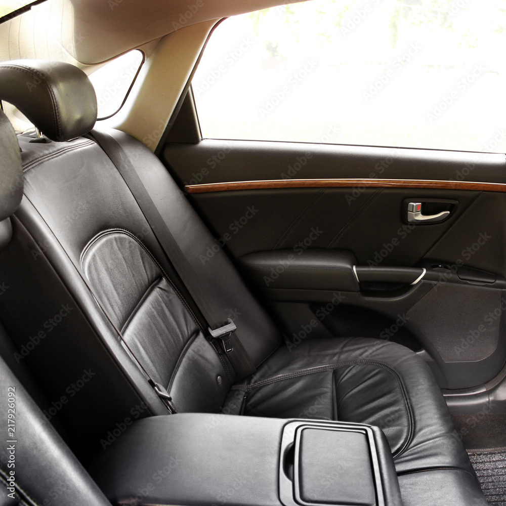 The rear seats of the car. Black leather interior