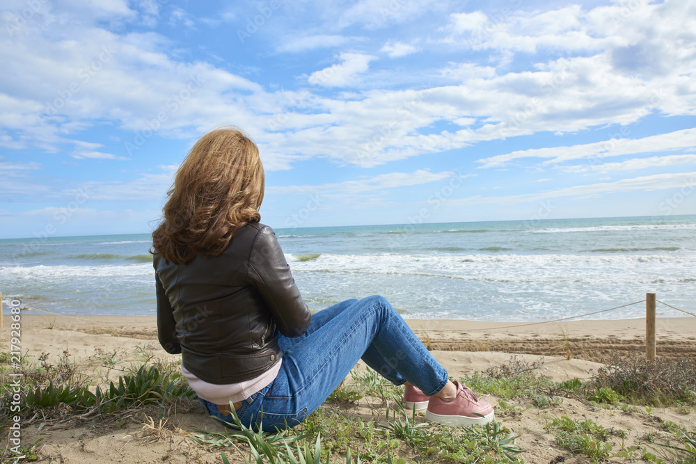Woman in casual clothing relaxing on the beach
