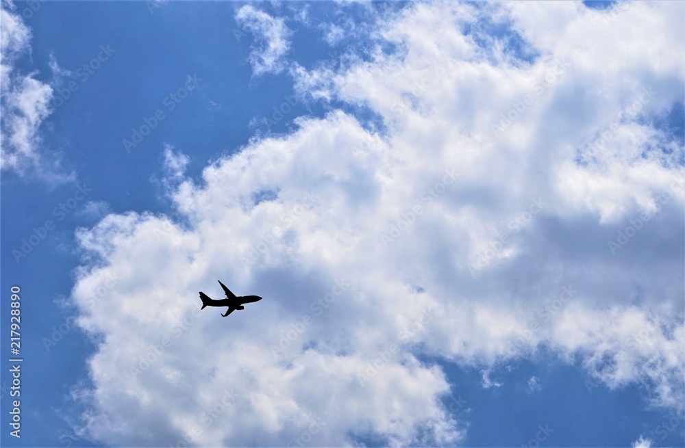 Blue sky and white clouds with silhouette of airplane flying, GA USA. Blue sky and white clouds with silhouette of airplane flying, GA USA.