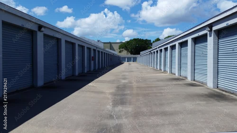 4K video driving from end to end down aisle / corridor of public storage property between storage unit buildings on both sides. 4K video driving from end to end down aisle / corridor of public storage property between storage unit buildings on both sides.