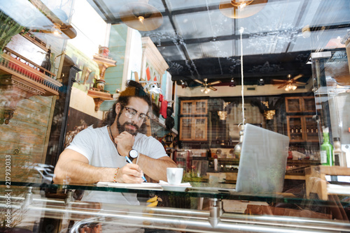 My ideas. Handsome nice man writing in the notebook while noting down his ideas