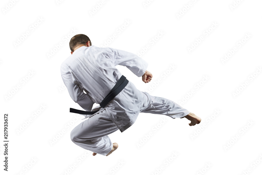 A kick in jump an athlete is training on a white background isolated A kick in jump an athlete is training on a white background isolated