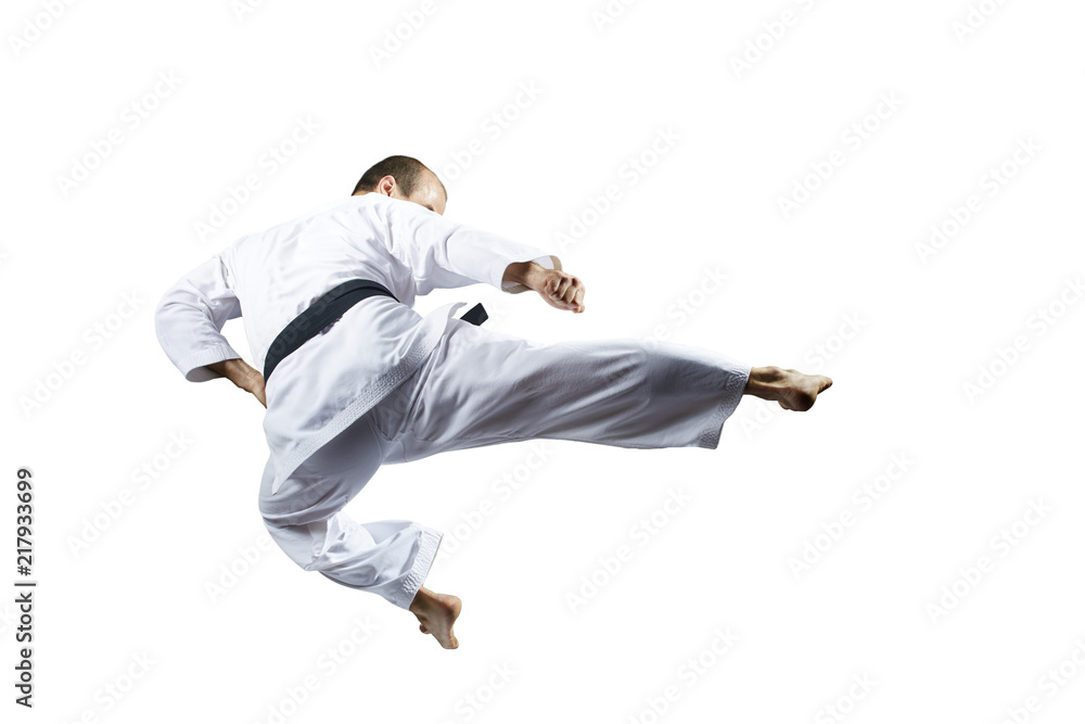 A kick kicked in the jump athlete beats against a white background isolated A kick kicked in the jump athlete beats against a white background isolated