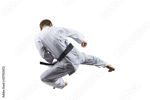 A kick in jump an athlete is training on a white background isolated